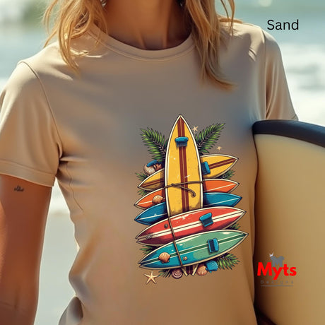 Person wearing a sand colored t-shirt with colorful surfboard design and 'Myts' branding.