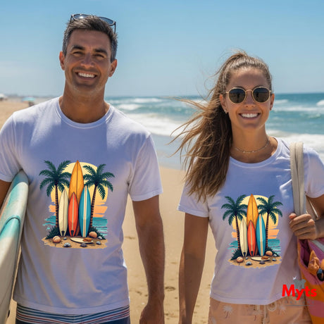 Two people on a beach wearing t-shirts with a tropical design featuring surfboards and palm trees.