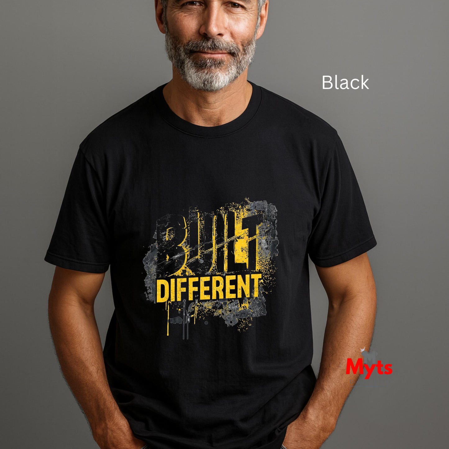 Man wearing a black t-shirt with 'Build Different' text on a gray background