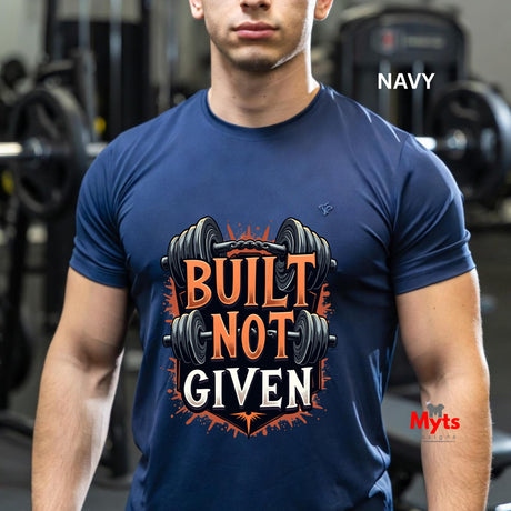 Man wearing a navy t-shirt with 'Built Not Given' graphic in a gym setting