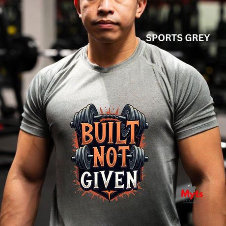 Person wearing a gray t-shirt with 'Built Not Given' graphic and weights in a gym setting.