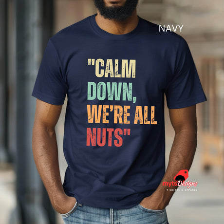 A man wearing a navy retro-style casual tee featuring bold distressed vintage typography reading “Relax — We’re All Weird Here,” printed on ultra-soft Gildan 64000 cotton.

