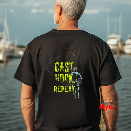 Man wearing a black t-shirt with 'CAST HOOK REPEAT' text and graphic, standing by water.