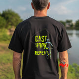 Person wearing a black t-shirt with 'CAST HOOK REPEAT' text and fishing graphic outdoors.