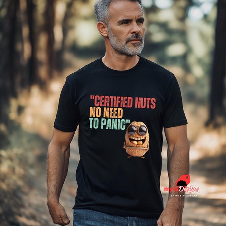A senior man walking in the bush wearing Retro-style casual tee featuring bold vintage script reading “Certified Nuts, No Need to Panic” in distressed lettering, printed on a black ultra-soft Gildan 64000 cotton.

