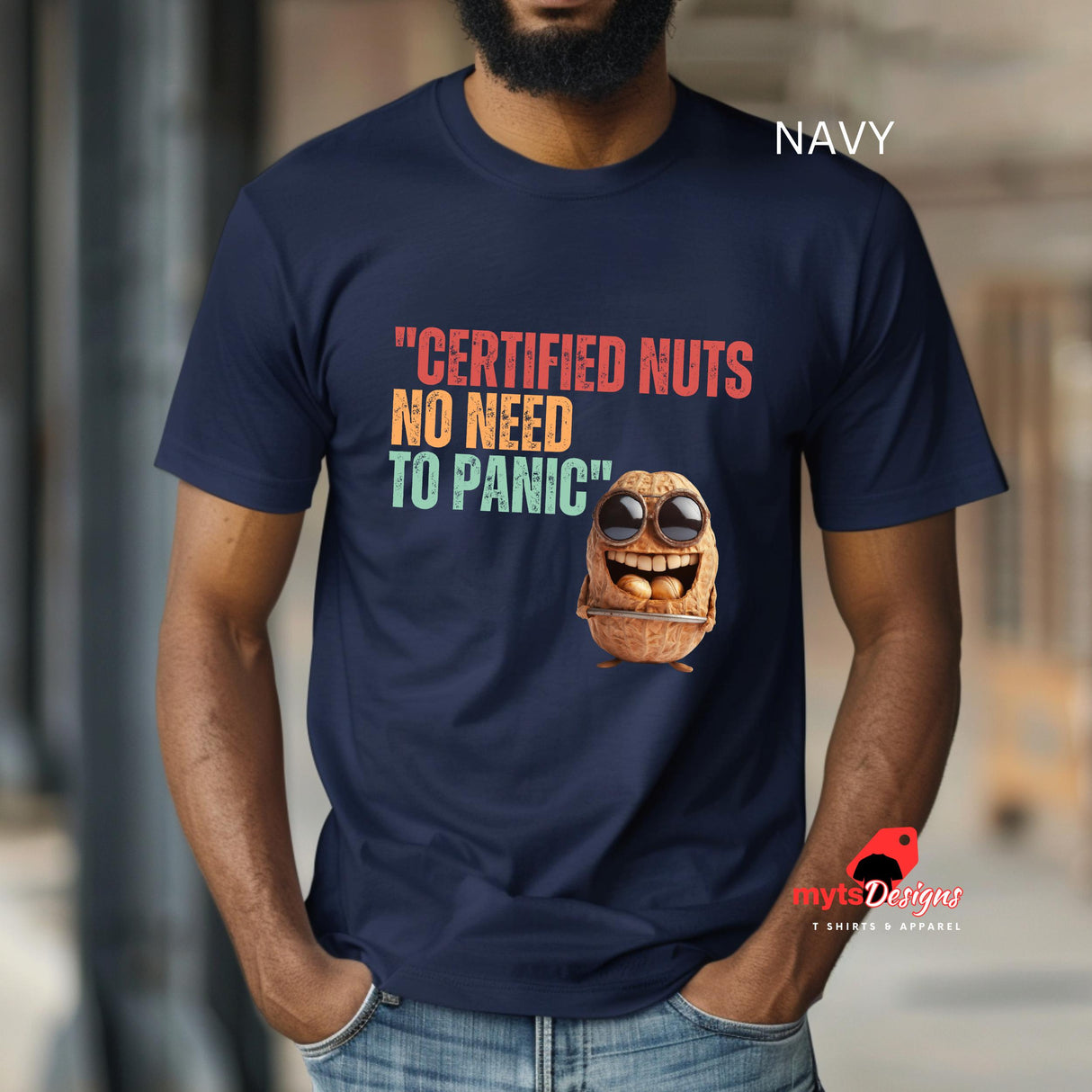 A man wearing a navy colored Retro-style casual tee featuring bold vintage script reading “Certified Nuts, No Need to Panic” in distressed lettering, printed on ultra-soft Gildan 64000 cotton.

