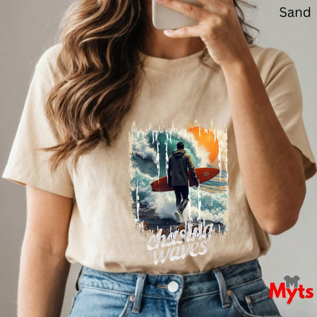 Person wearing a sand t-shirt with a graphic design and text, taking a mirror selfie.
