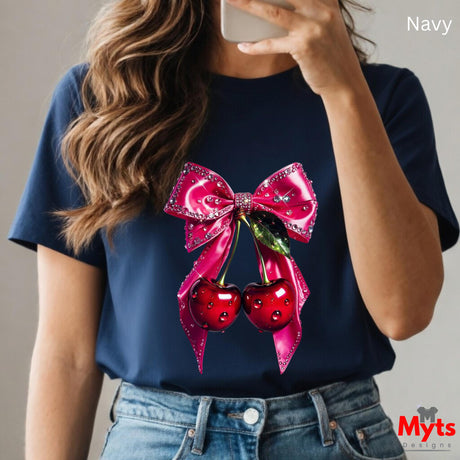 Person wearing a navy blue t-shirt with a pink bow and red cherries design, taking a selfie.