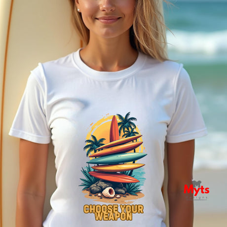Person wearing a white t-shirt with a colorful graphic of surfboards and palm trees, standing on a beach.