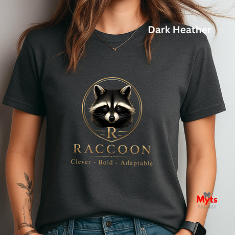 A woman wearing a dark heather charcoal t-shirt with a gold and black raccoon graphic and the text 'RACCOON Clever - Bold - Adaptable'. The image has a text overlay 'Dark Heather' at the top right and a watermark 'Myts' at the bottom right.