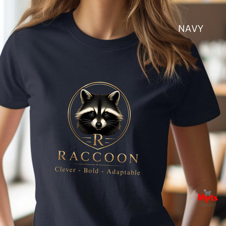 A navy blue short-sleeve t-shirt with a graphic of a raccoon inside a gold circular frame and the text 'RACCOON Clever - Bold - Adaptable' on the front. The image is shown on a model in a blurred indoor setting, with 'NAVY' text in the top right and a 'Mits' watermark in the bottom right.