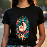 A person wearing a black short-sleeve T-shirt with a colorful seashell and sea plant graphic on the front, photographed outdoors with a blurred background.