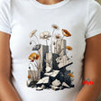 A white short-sleeve crewneck t-shirt featuring a detailed graphic print of wildflowers blooming from broken gray stone blocks. The shirt is shown on a model, with the brand name 'Myts' printed in red on the lower right side of the graphic.