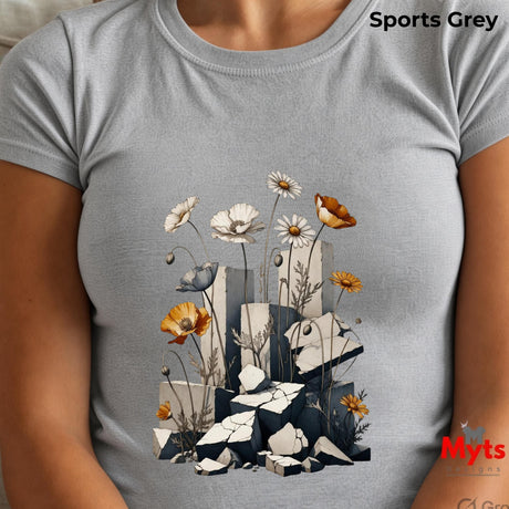 A light grey crewneck t-shirt featuring a graphic print of white daisies, orange poppies, a small bird, and broken grey blocks, shown on a model. The text 'Sports Grey' is visible in the top right corner.