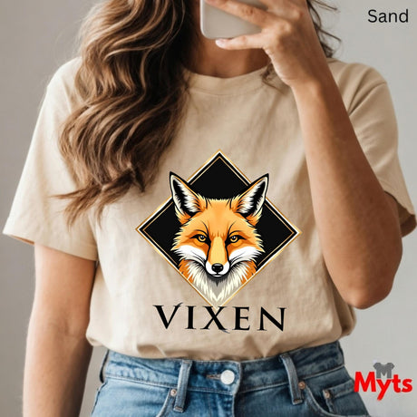 Person wearing a Sand t-shirt with a fox graphic and 'VIXEN' text, holding a phone.