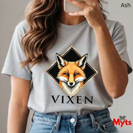 Person wearing a Ash t-shirt with a fox graphic and 'VIXEN' text, holding a phone.