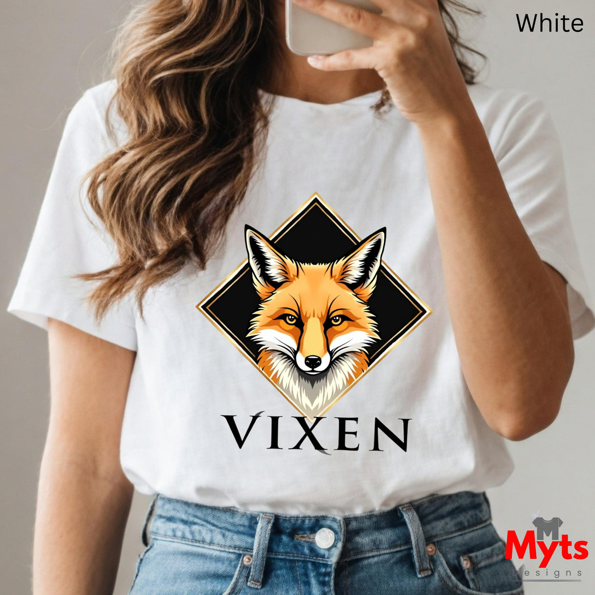 Person wearing a white t-shirt with a fox graphic and 'Vixen' text, holding a phone.
