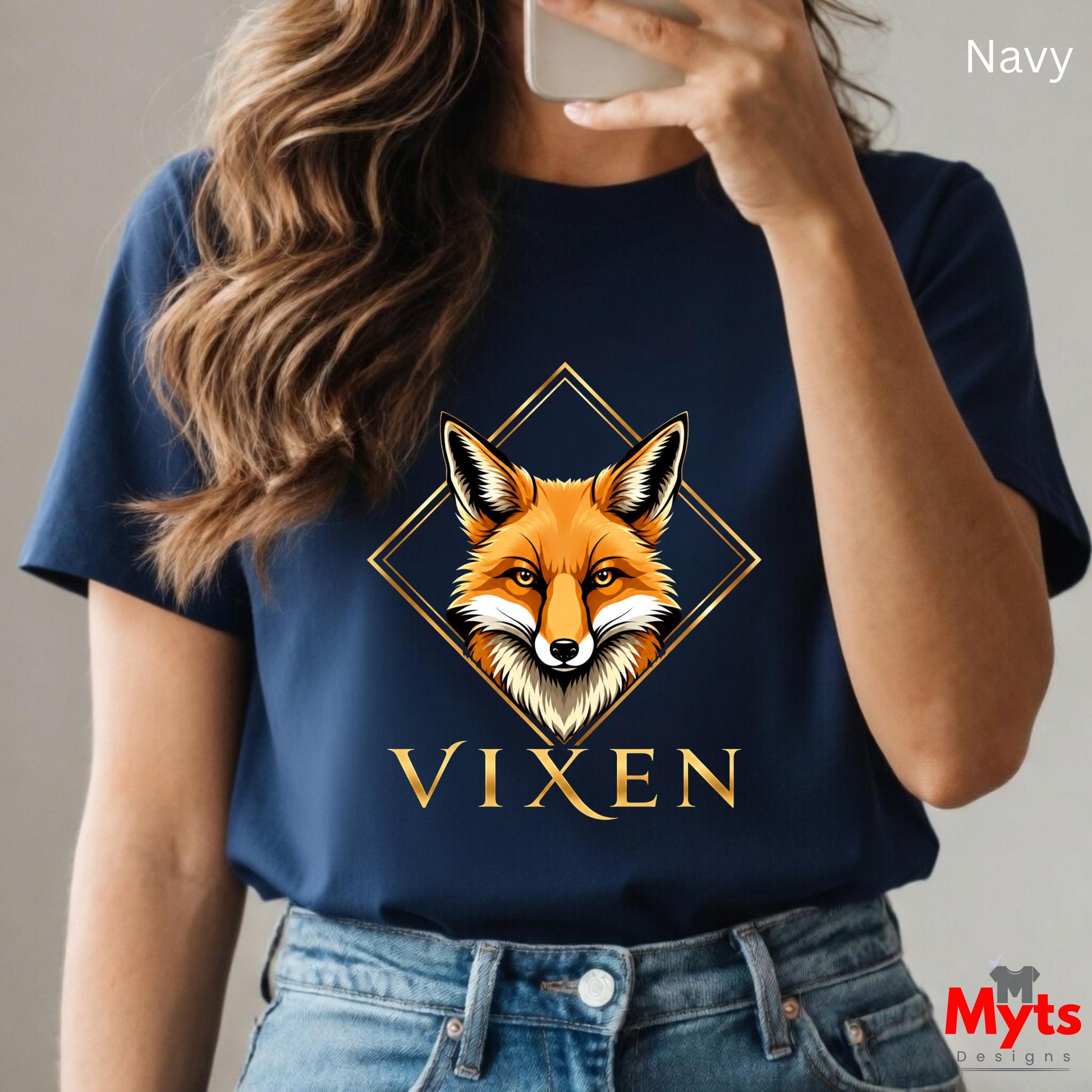 Person wearing a navy blue t-shirt with a fox graphic and 'Vixen' text, holding a phone.