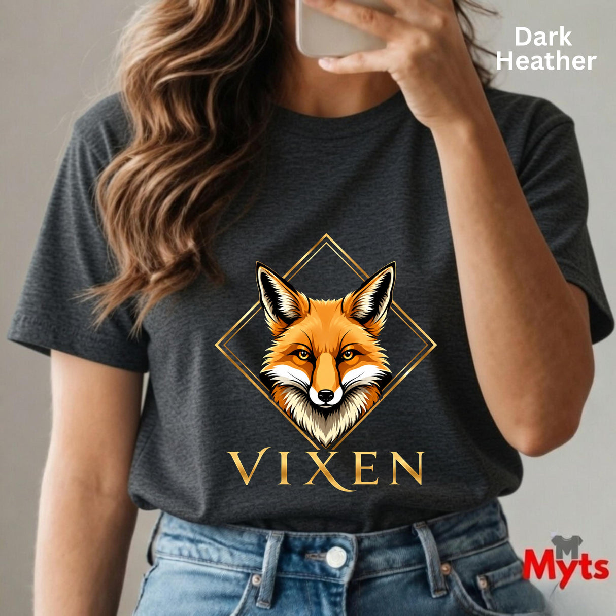 Person wearing a dark Heather t-shirt with a fox graphic and 'Vixen' text, holding a phone.