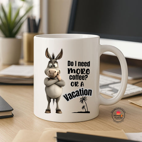 Ceramic coffee mug featuring a cartoon donkey with folded arms and the humorous quote “Do I Need More Coffee or a Vacation?” Ideal novelty gift for coffee lovers, office workers, and animal enthusiasts.