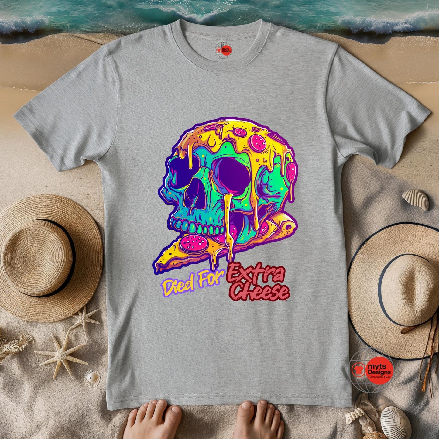 Gray t-shirt with a colorful skull design and 'Died for Extra Cheese' text on a sandy background.