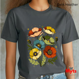 A person wearing a dark heather charcoal gray t-shirt with a colorful graphic of stylized poppy flowers in orange, yellow, blue, and cream. The text 'Dark Heather' is visible in the top right corner, and a 'Myts Designs' logo is in the bottom right corner.