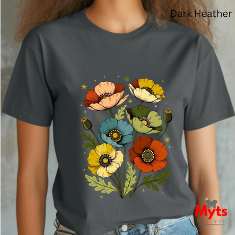 A person wearing a dark heather charcoal gray t-shirt with a colorful graphic of stylized poppy flowers in orange, yellow, blue, and cream. The text 'Dark Heather' is visible in the top right corner, and a 'Myts Designs' logo is in the bottom right corner.