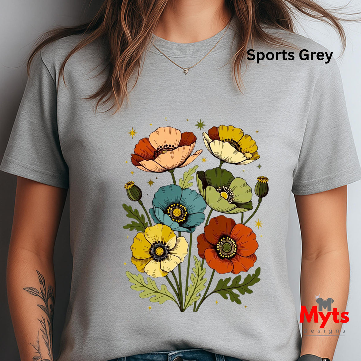 A person wearing a light gray short-sleeve T-shirt with a colorful poppy floral graphic on the front. The text 'Sports Grey' appears near the upper right, and a red 'Myts' logo watermark is visible in the lower right corner.