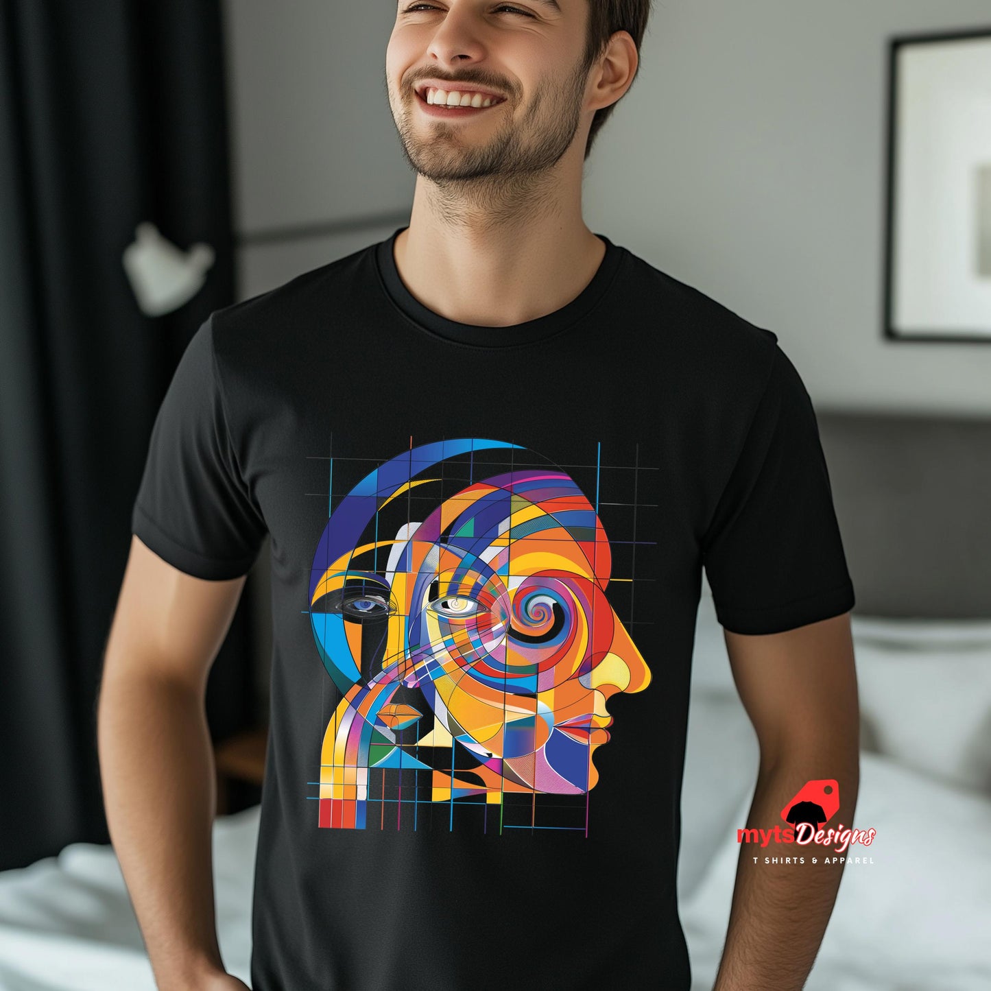 Man wearing a black t-shirt with a colorful abstract design, standing in a room.
