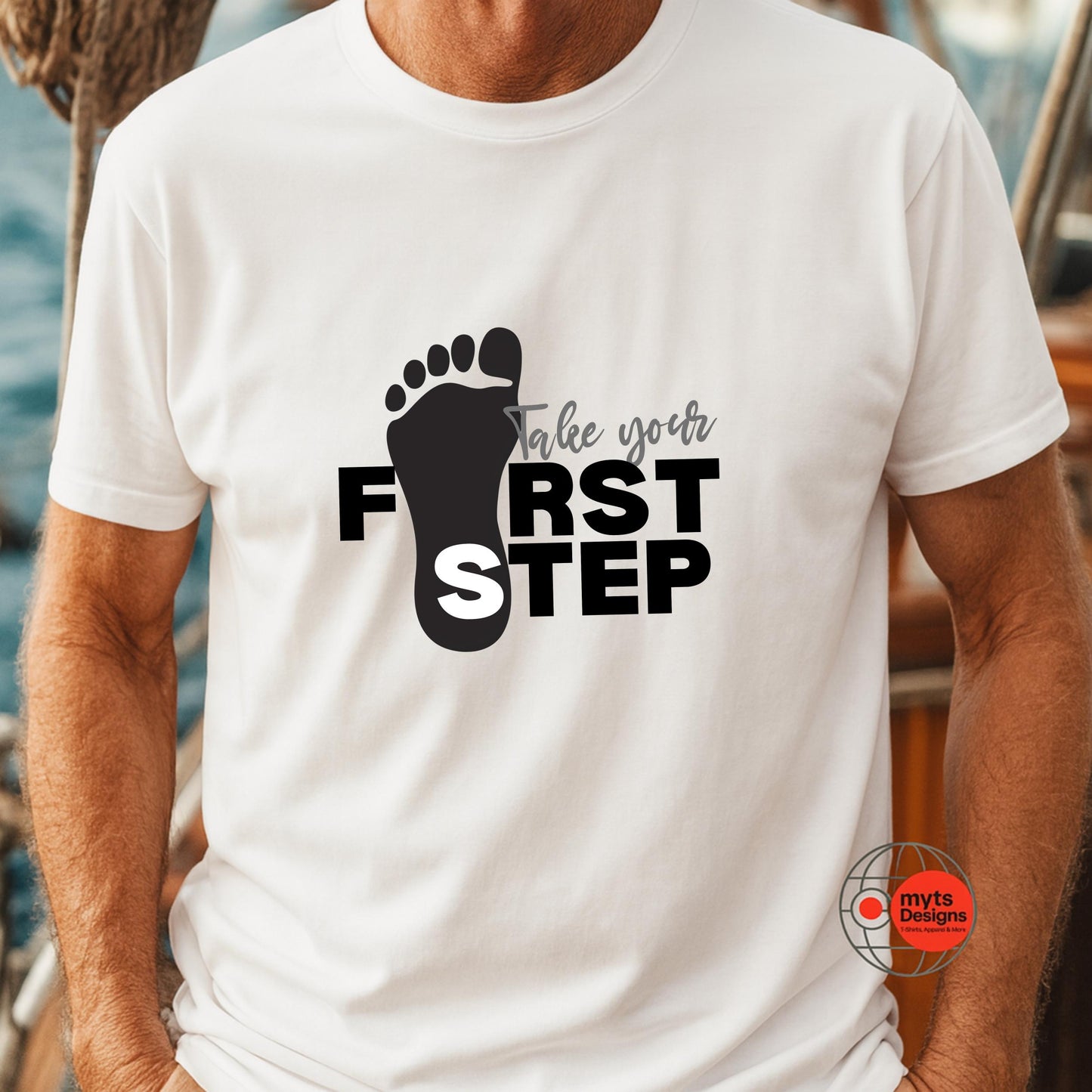 White t-shirt with black footprints and text 'Take your first step' on a blurred background