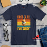 Casual tee displaying a retro-style donkey illustration with bold “First of All, I’m a Delight” vintage text, printed on ultra-soft Gildan 64000 cotton.

