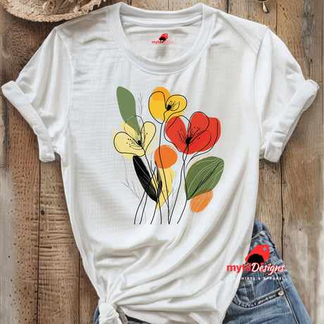 White t-shirt featuring minimalist floral line art with abstract red, yellow, and orange flowers and green leaves, laid flat on a wooden surface with rolled sleeves.