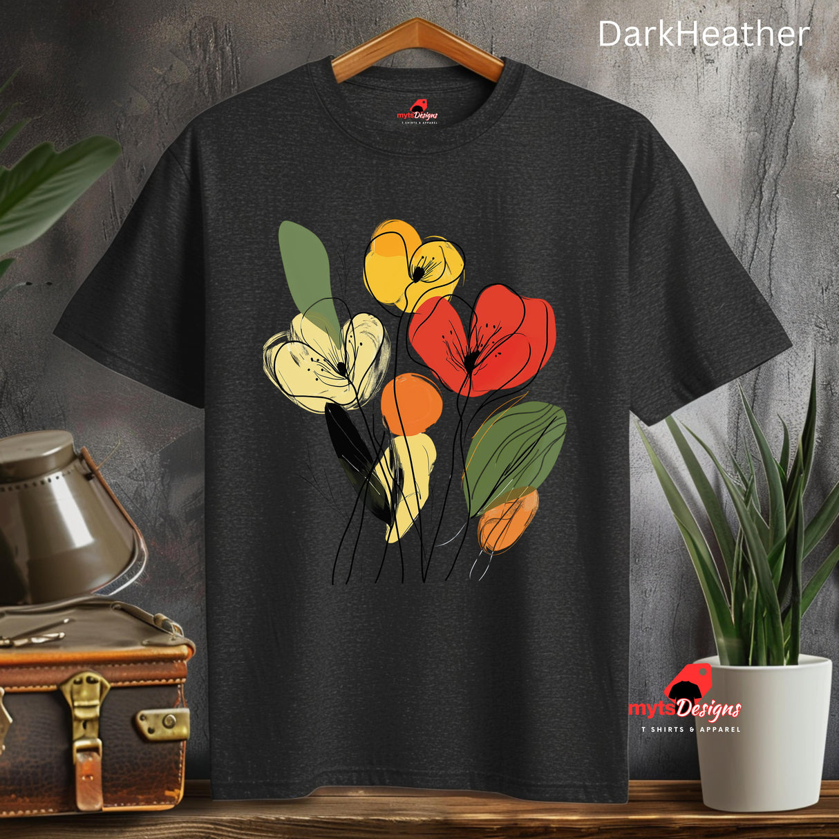 Dark Heather t-shirt featuring minimalist floral line art with abstract red, yellow, and orange flowers and green leaves, hanging on a wooden hangar.