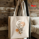 Beige tote bag with floral design hanging on a wooden wall