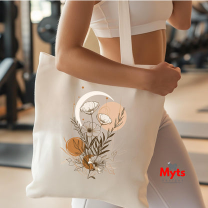 Person holding a white tote bag with floral design in a gym setting, featuring the brand 'Myts'.