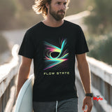 Man wearing a black t-shirt with colorful design and 'Flow State' text, holding a surfboard on a bridge.