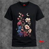 A black short-sleeve t-shirt with a colorful graphic print of wildflowers, a crescent moon, and stars on the front, displayed against a textured gray background.