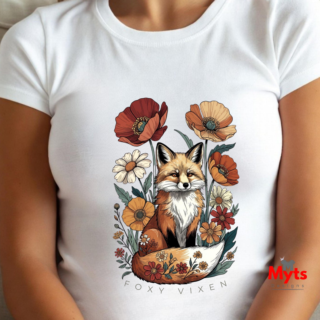 A white short-sleeve crewneck t-shirt featuring a colorful graphic of a fox surrounded by flowers, with the text 'FOXY VIXEN' printed below. The shirt is shown on a model.