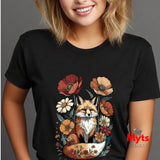 A woman wearing a black short-sleeve t-shirt with a colorful graphic of a fox sitting in a bowl surrounded by flowers. The photo is cropped from the mouth down, showing the black fabric and the graphic print clearly against a neutral gray background.