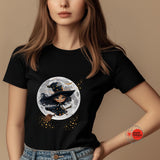 Person wearing a black t-shirt with a witch graphic design on a beige background