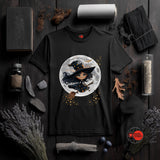 Black t-shirt with a witch graphic on a dark wooden surface with Halloween-themed decor.