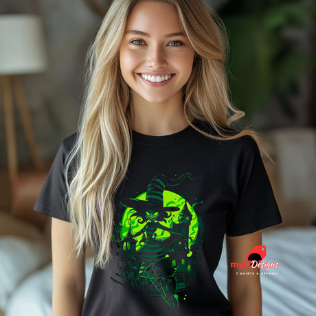 Woman wearing a black t-shirt with a green graphic design, standing in a blurred indoor setting.