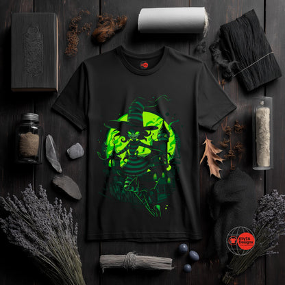 Black t-shirt with green graphic design on a dark wooden surface with various items.