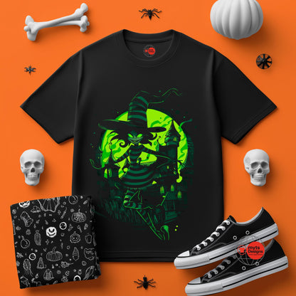 Black t-shirt with green witch design on an orange background with Halloween-themed accessories.