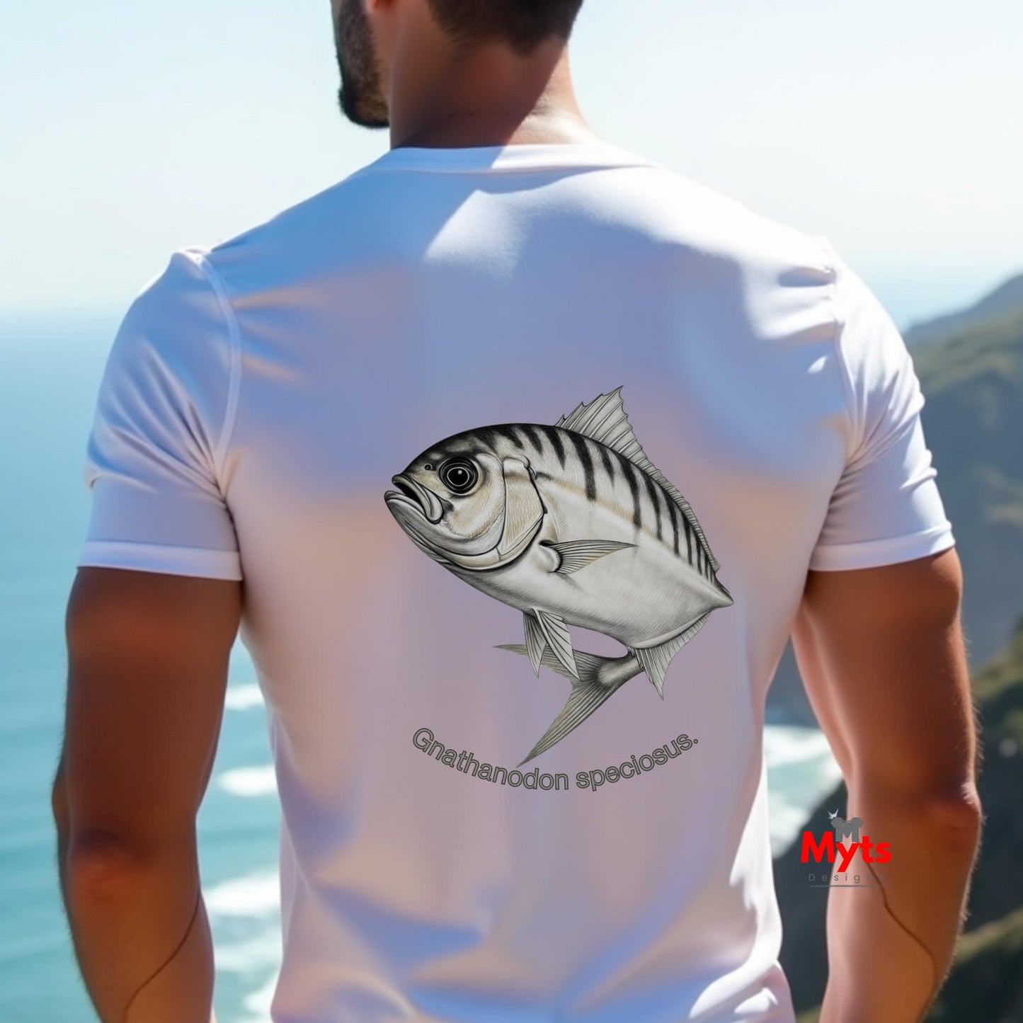 Man wearing a white t-shirt with a fish design on the back, standing by the ocean.