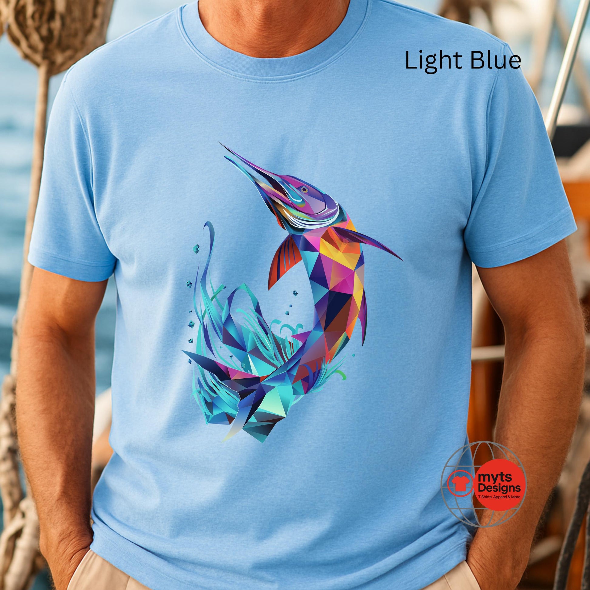 Light blue t-shirt with a colorful fish design worn by a person, with 'myts Designs' logo.