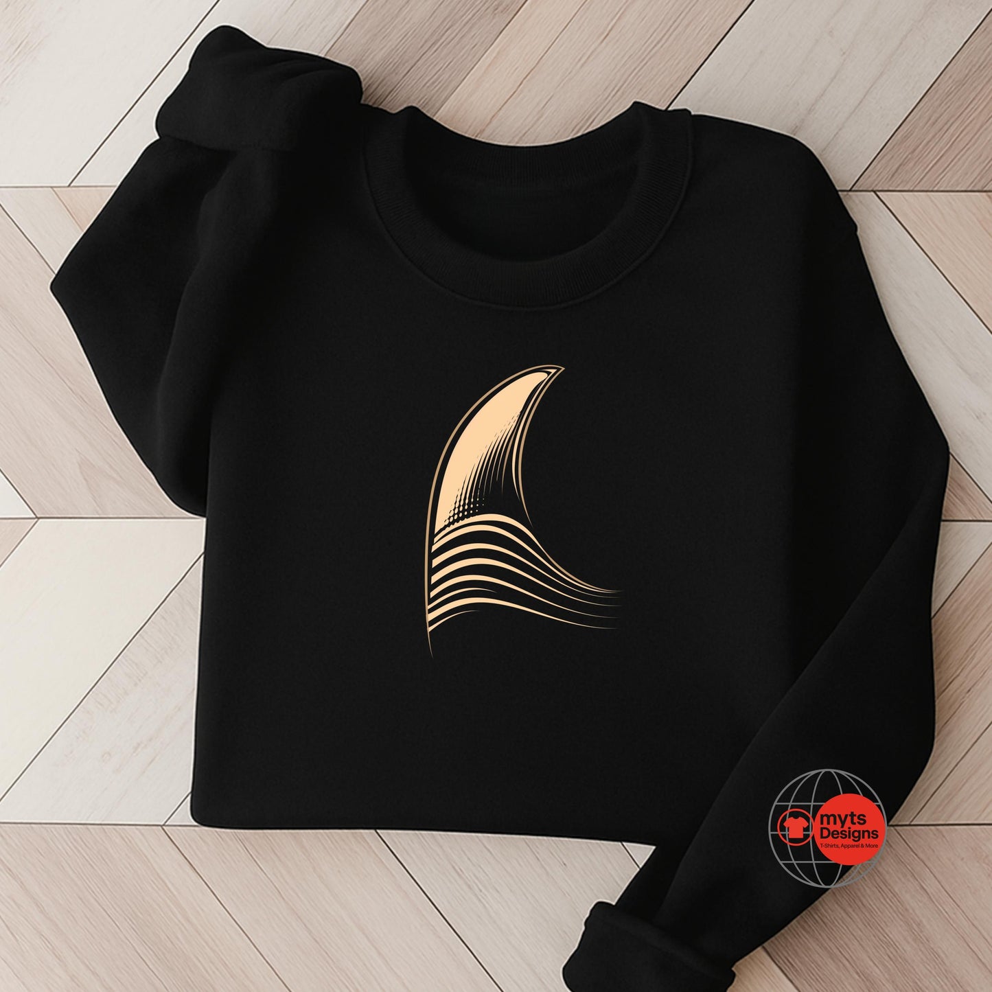 Black sweatshirt with a gold abstract design on a wooden floor