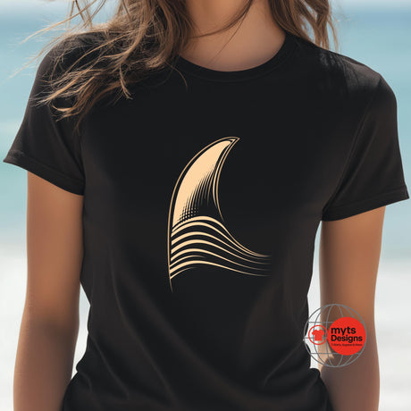 Black t-shirt with a gold abstract design on a blurred beach background