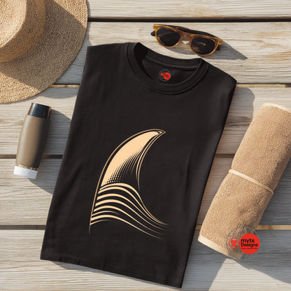 Black t-shirt with a gold graphic on a wooden surface with a hat, sunglasses, and towel.