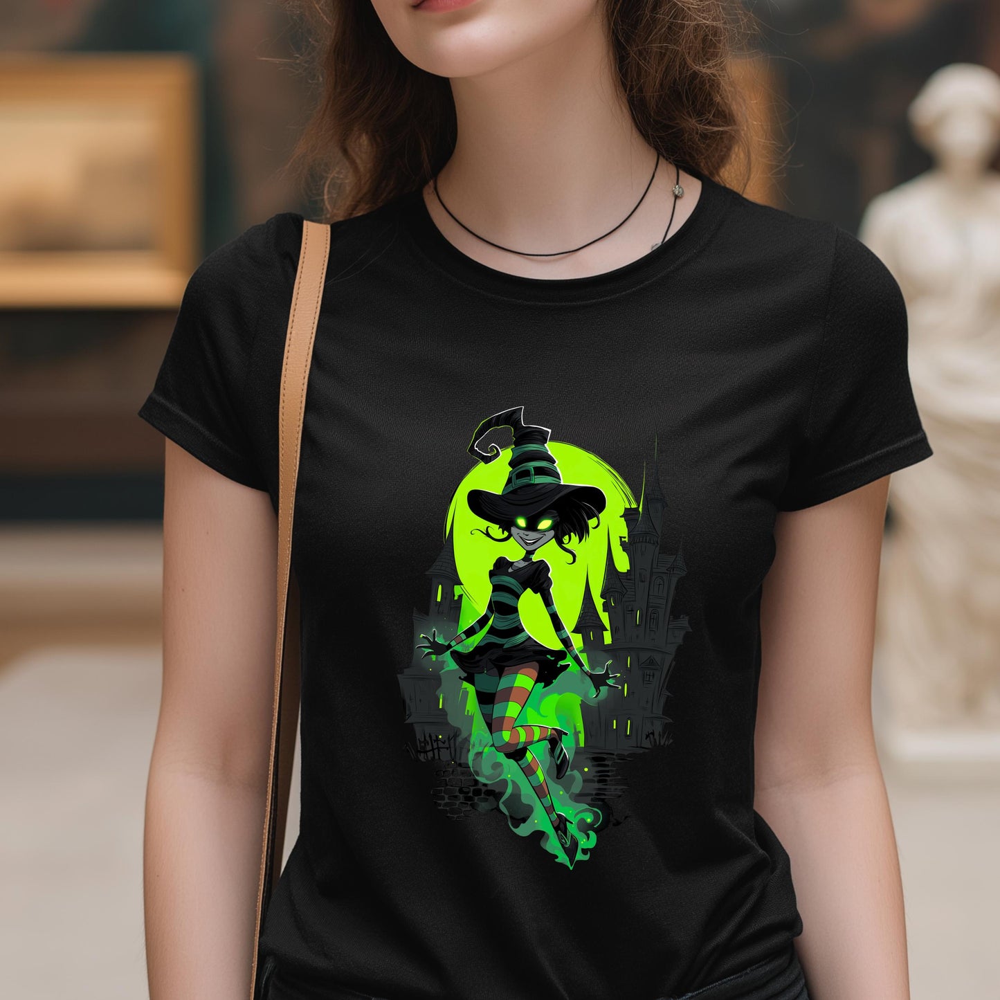 Person wearing a black t-shirt with a green witch graphic design.